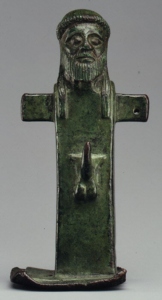 Small archaic Greek bronze herm with a bearded head above a squared pillar-like body.